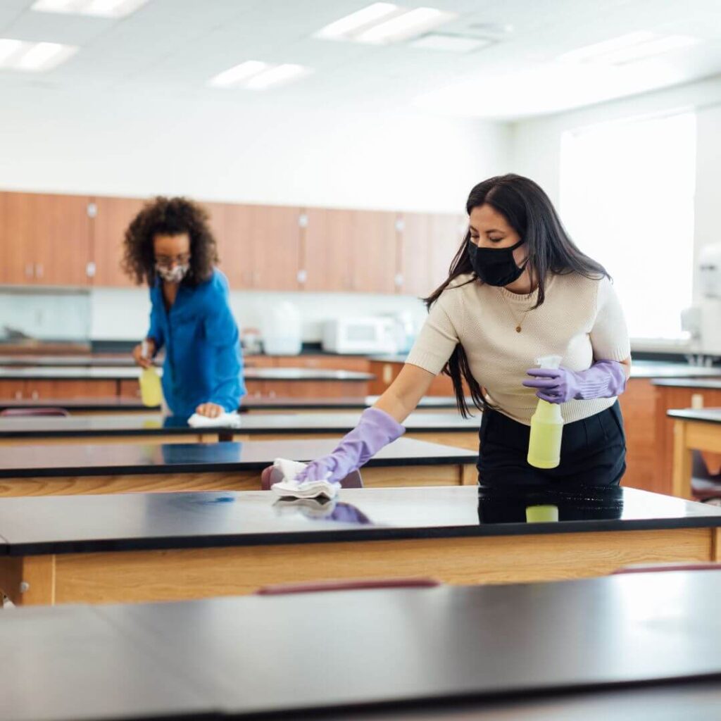 staff cleaning tables in school