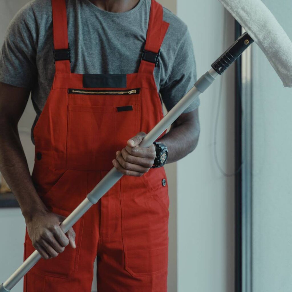 A cleaner holding a mop